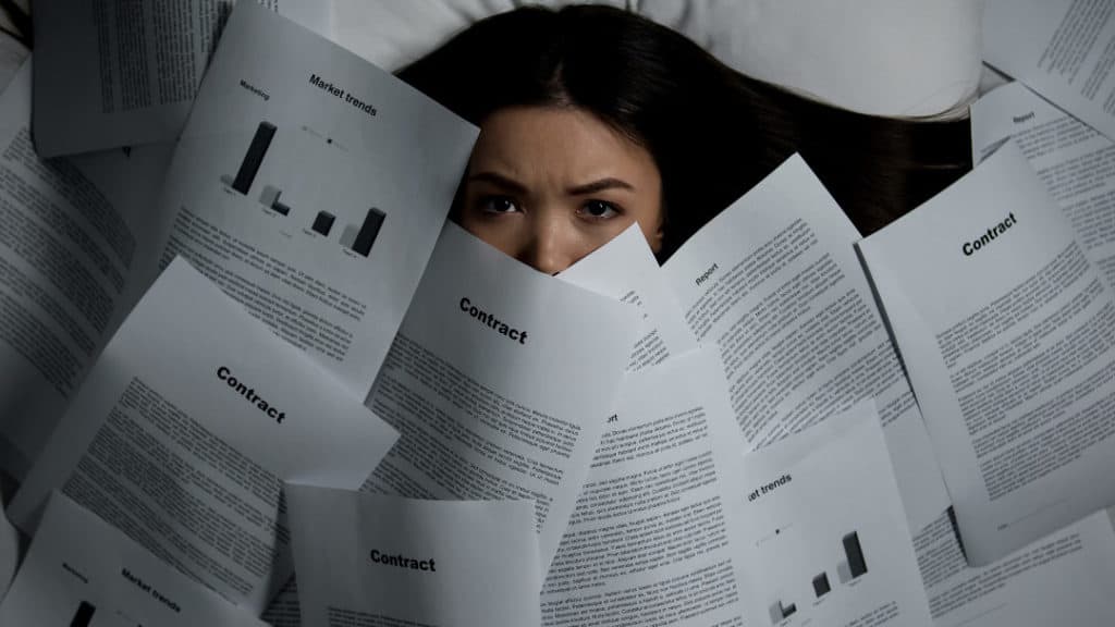 woman covered by piles of documents