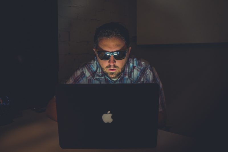 man using laptop to ensure mobile security